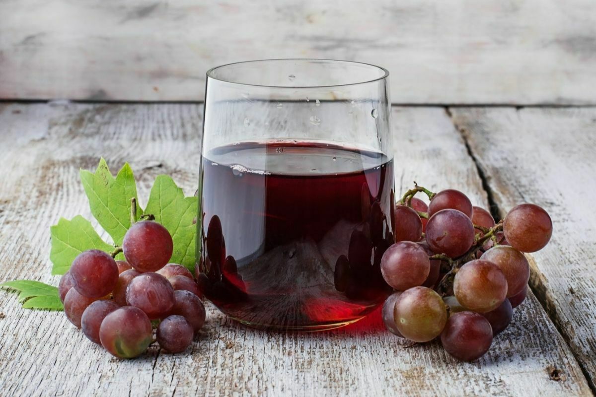 Glass of grape juice and grape fruit on a table