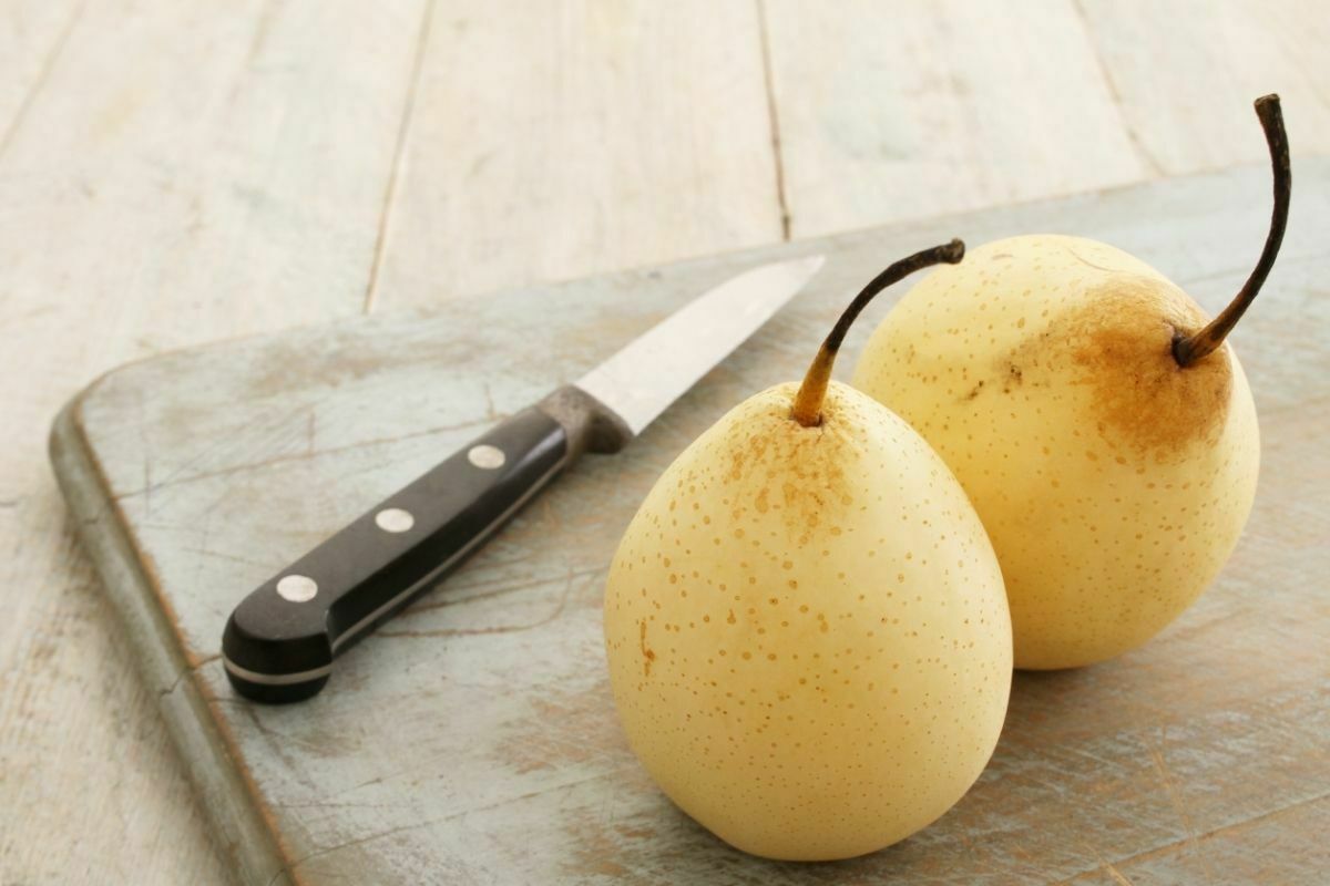 Pears on a chopping board beside a knife