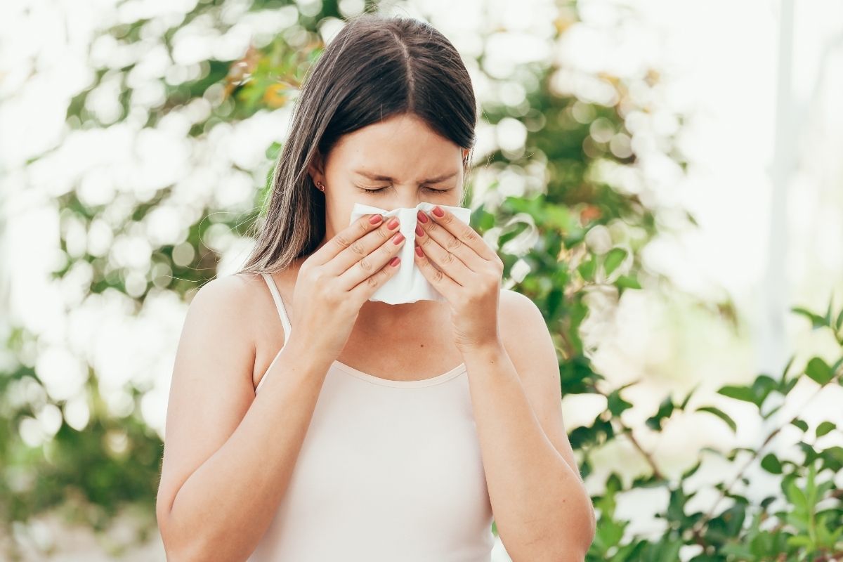 Woman sneezing on a handkerchief